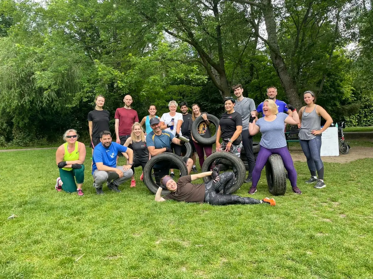 A large Bootcamp SE16 group sitting together on the grass at Stave Hill after a spring session