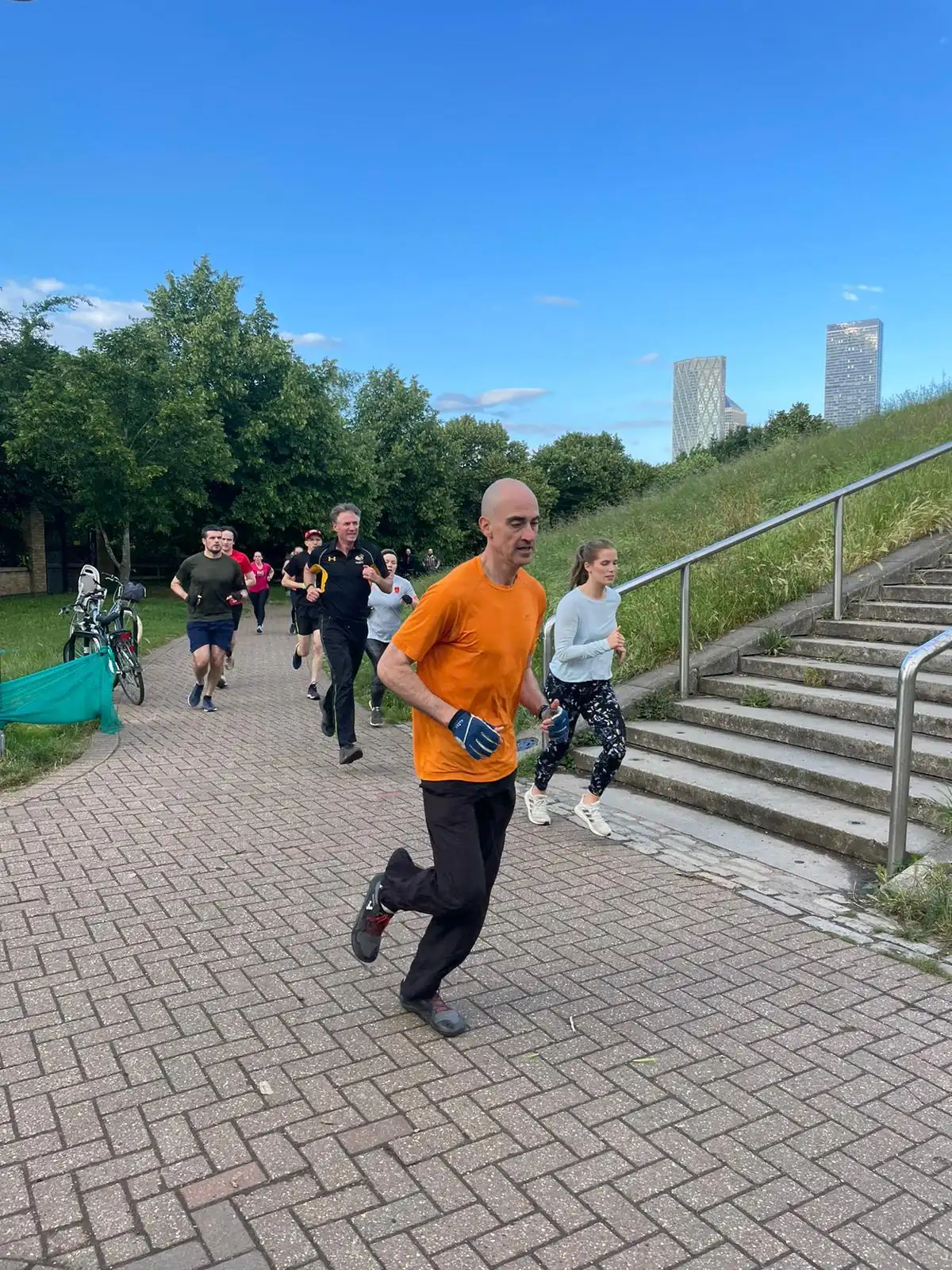 A Bootcamp SE16 member running up the path at Stave Hill on a bright morning
