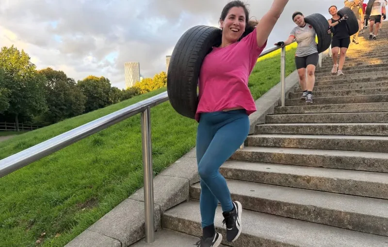 Bootcamp SE16 members running down the steps at Stave Hill with the London skyline behind
