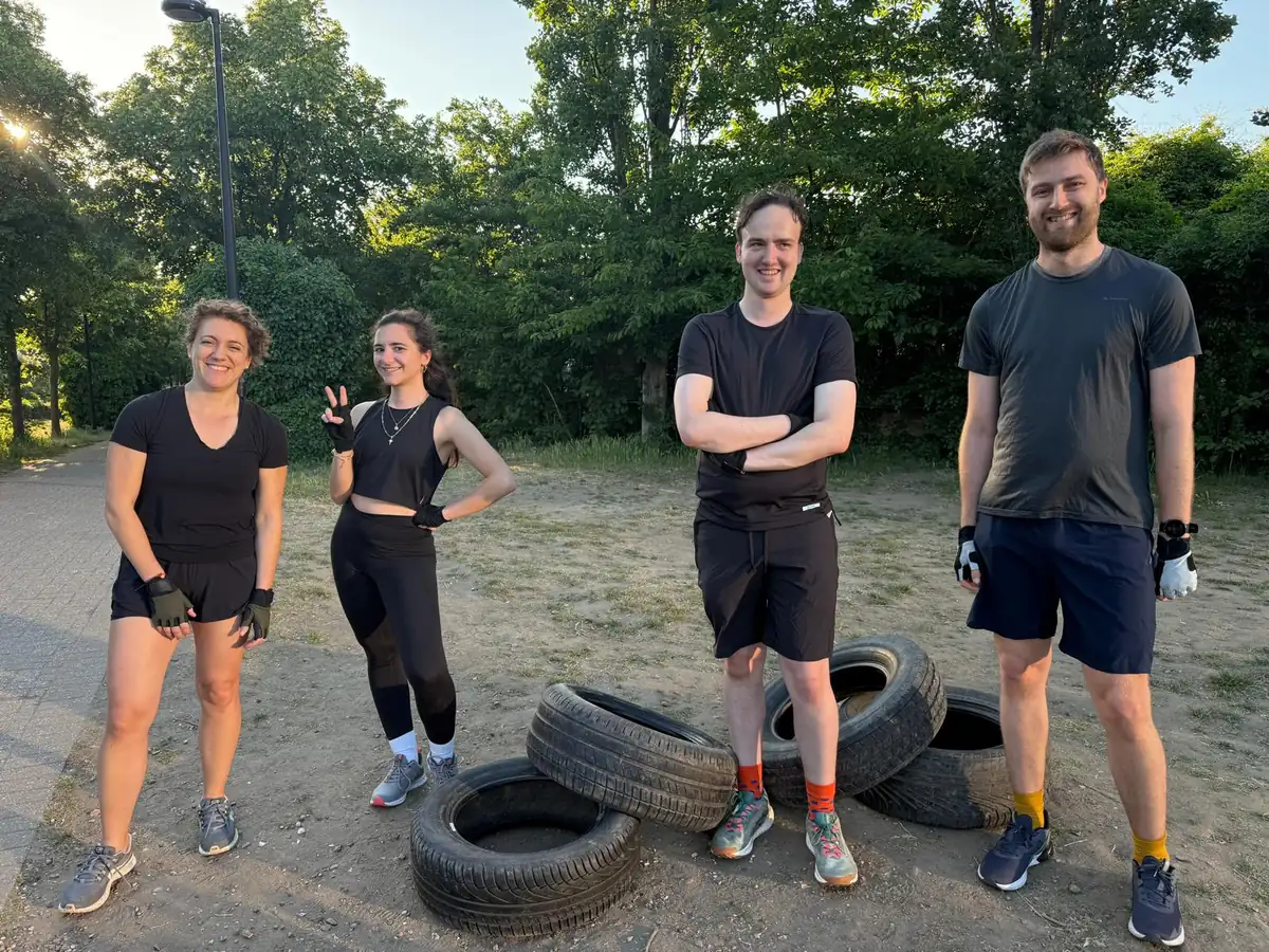 Four Bootcamp SE16 members standing with tyres on the path at Stave Hill on a bright morning