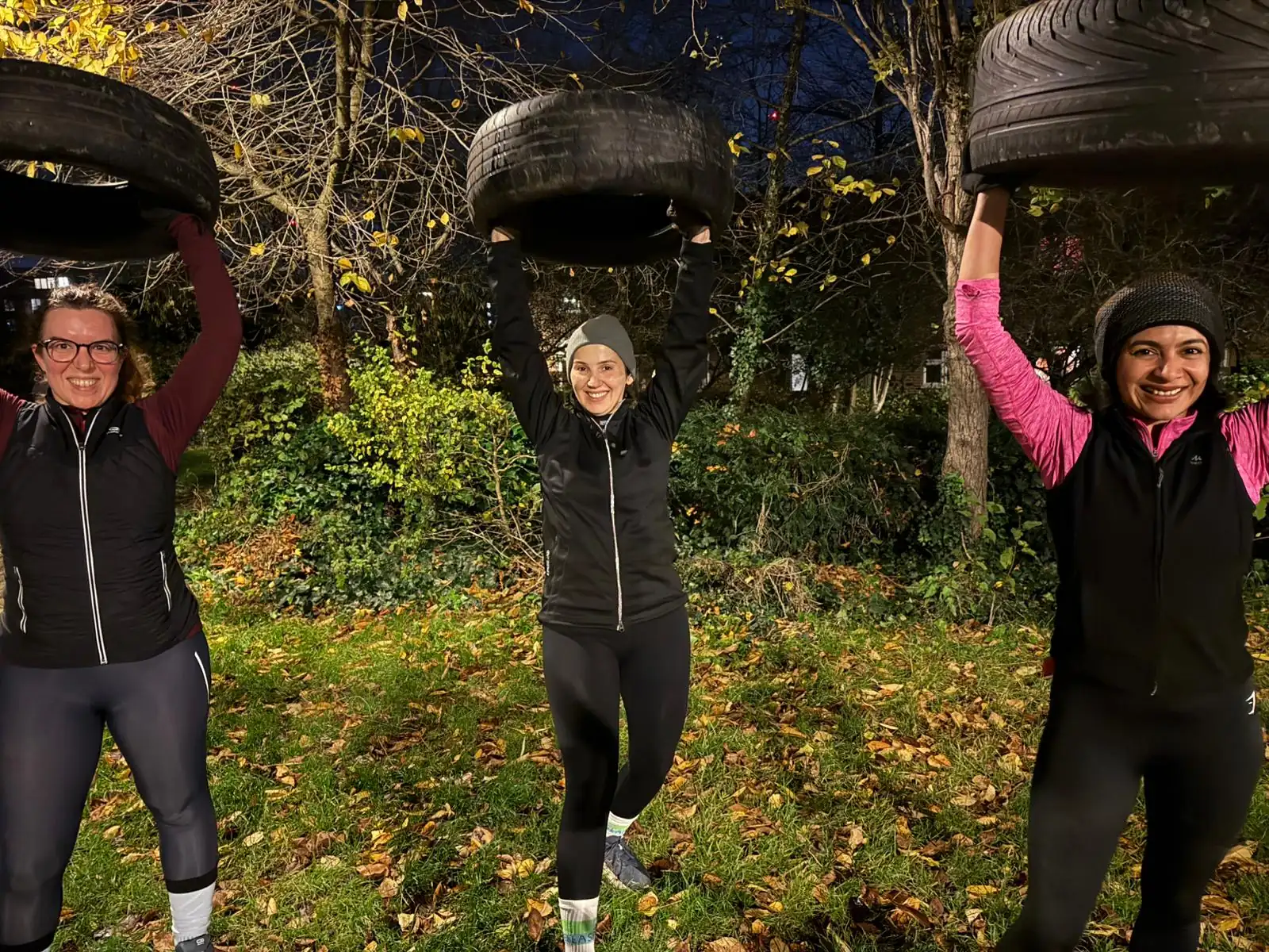 Members lifting tyres overhead during a winter session at Stave Hill, wrapped up against the cold