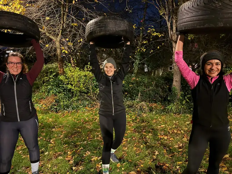 Members lifting tyres overhead during a winter session at Stave Hill, wrapped up against the cold
