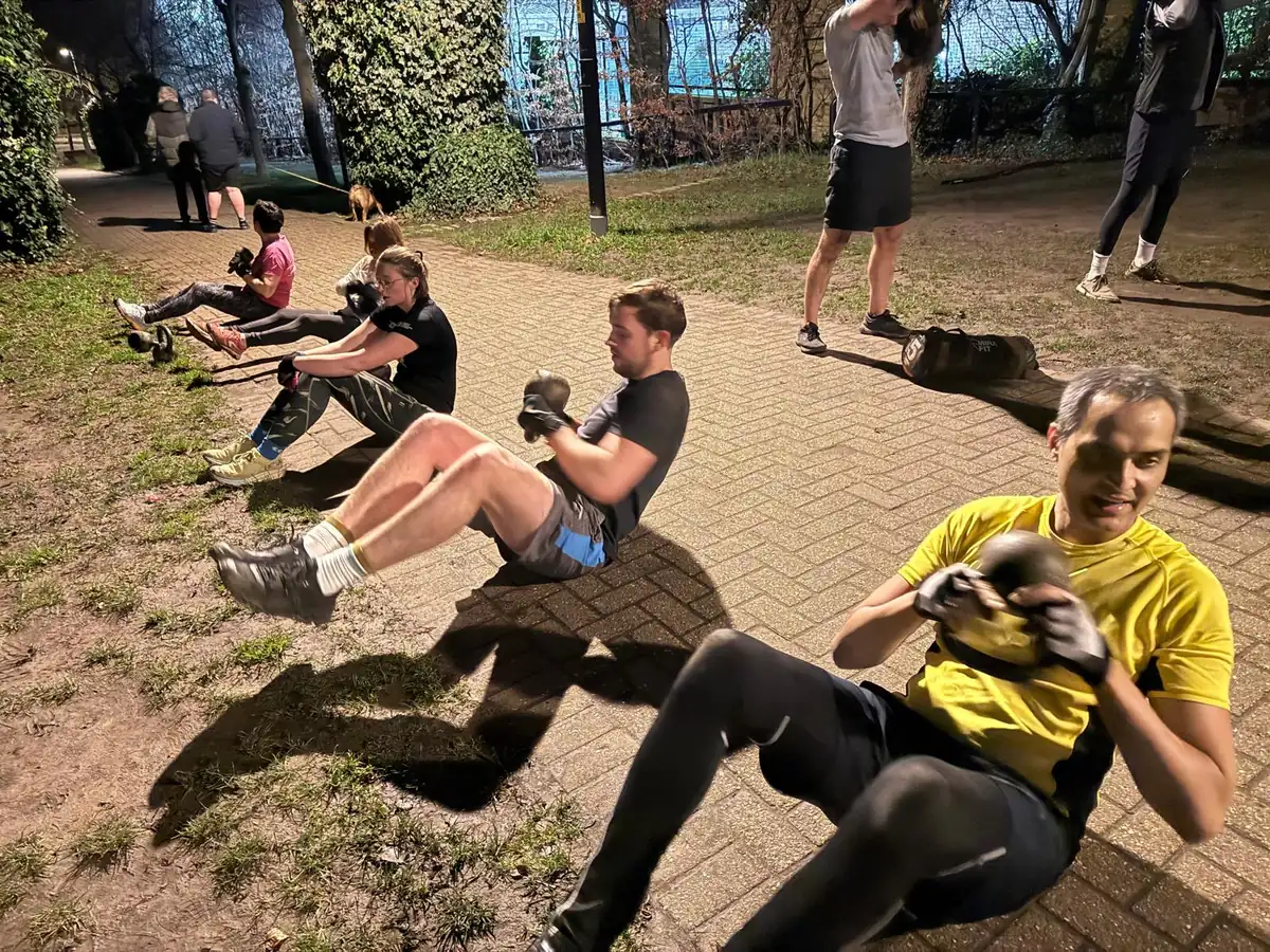 A coached kettlebell session in progress on the path at Stave Hill Ecological Park in Canada Water