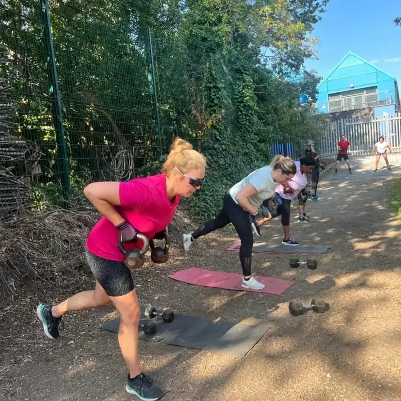 Members doing kettlebell rows on mats along the path at Stave Hill